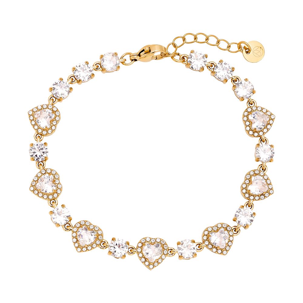 Podroben pogled na lesketajočo zlato zapestnico iz vrste srčastih členov s kamni, kot jo nosi model. Zapestnica je oblikovana tako, da tvori popoln set z biserno ogrlico z zlato pentljo in srčkom