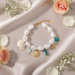 Zapestnica Fish Agate Pearl - flat lay z rožami - biseri polžja hišica ribica zlata školjka turkizni agat - kirurško jeklo 316L zlata pozlata